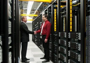 Two people shaking hands in a data center as they sign a partnership deal for multi cloud direct connect