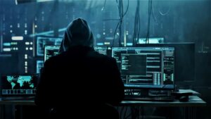 A hacker at a terminal with multiple monitors using code to break into a cloud