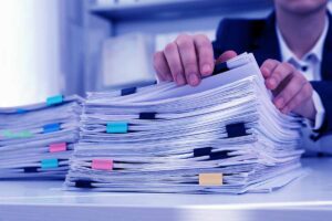 Woman working with documents at table in office, closeup