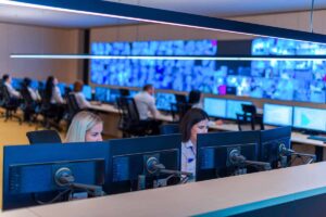 A security operations center in action, people look at big screens