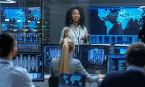 Chief Project Engineer Holds Briefing for a Team of Scientists that are Building Machine Learning System. Displays Show Working Model of Neural Network.